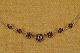 Granat collier 
halskæde med 
facet slebne 
granater 
fordelt i en 
stor center 
blomst 
flankeret af 3 
...