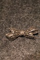 Gammel  broche 
i sølv med 
masser af små 
skinnende 
magasiter. 
Måler : 5x2cm.