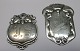 Par danske sølv 
frakke mærker. 
20. årh. H.: 
4,2 - 5,2 cm. 
B.: 3,5 - 4 cm. 
Stemplet.