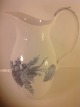 Blå blomst 
Svejfet.
Mælke / 
vandkande.
Højde: 20 cm.
Royal 
Copenhagen RC 
10 - ...