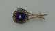 Brosche i 8 karat guld med blå emalje og rned ring af mindre og stor ægte perle. i alt 2 gr. 