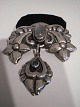 Skønvirke 
dobbeltbroche i 
830 sølv med 2 
cabochonslebne 
månesten. 
Stiliserede 
blomster og ...