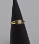 Ring i 14 karat 
guld med en 
perle á ca. 0,5 
cm. i diameter.
Ringstr. 56,5 
Ø17,9
Stemplet og 
...