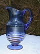 Glass jug on 
foot. Height 25 
cm. Condition: 
A little wear 
on the gold 
edges.