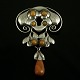 Evald Nielsen. 
Skønvirke 
Broche i Sølv 
med rav.
Tegnet og 
udført hos 
Evald Nielsen 
1879 - 1958. 
...