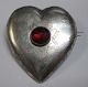 Antik dansk 
hjerteformet 
brosche i sølv, 
19. årh. Med 
rød glas flus. 
Med 
indgraverede 
...