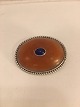 Broche med rav 
og blå safir og 
sølv perlebord 
i kanten.
Sølv 830 s GPB 
( G.P. Bøttcher 
- ...