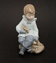 Nao/Lladro, 
Spanien, 
Siddende dreng 
med kanin og 
taske. Højde 16 
cm. Fin stand. 
Pris: 800 kr.