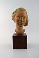 Johannes Hedegaard, eget værksted. Buste af ung kvinde i keramik på træsokkel.
