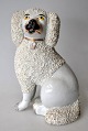 Staffordshire 
puddelhund, 19. 
årh. Hvid 
fajance med 
"krømmel" og 
bemalinger. 
Højde.: 18 cm.