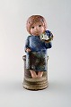Lisa Larson for 
Gustavsberg. 
Pige med 
blomster i 
glaseret 
keramik. 
1900-tallet.
Måler: 23 x 11 
...
