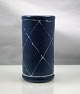 Allis. Blå 
keramik vase, 
der er 
dekoreret med 
hvide striber, 
der danner 
romber.
Design ...
