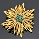 A brooch set with emeralds, mounted in 14k gold