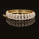 A 18kt gold bangle with 13 diamonds. Size inside: 5,6x6cm