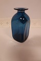 Vase fra Kastrup Vase fra Kastrup Glasværk
Fra Capri Serien, klart blåt glas
Blå vase med hals med krave
Design: Jacob E. Bang (1899-1965)
Produceret på Fyns Glasværk i 1961 (udgår af 
produktion i 1973)
H: ca. 15cm
Flot stand