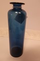 Vase fra Kastrup Glasværk
Fra Capri Serien, klart blåt glas
Blå rund/cylinderformet vase med hals med krave
Design: Jacob E. Bang (1899-1965)
Produceret på Fyns Glasværk i 1961 (udgår af 
produktion i 1973)
H: 21,5cm