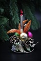 Old Christmas decorations made of metal, glass balls, branch cones and small 
candles in glass.