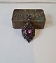 Antik medaljon med smukke lilla glas sten fattet i patineret metal.På bagsiden er der en lille ...