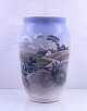 Royal 
Copenhagen. 
Vase nr. 
2746/1217. 
På forsiden er 
et landskab med 
bakker og lille 
hus, på ...