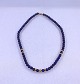 Halskæde, der 
består af 
perler i 
blåsafir og 14 
karat 
guldperler, 
halskæden er 
lukket med ...