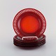 Monica Bratt 
for Reijmyre. 
Seks 
tallerkener i 
rødt mundblæst 
kunstglas. 
1950/60'erne.
Diameter: ...
