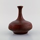 European studio ceramicist. Narrow neck unique vase in glazed stoneware. 
Beautiful glaze in reddish brown shades. Late 20th century.
