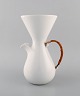 Freeman 
Lederman. Stor 
modernistisk 
kande i 
hvidglaseret 
keramik med 
hank i flet. 
Midt ...