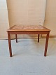 Sofabord i 
fineret teaktræ 
med kakler fra 
1960erne.
H 52cm B 72cm 
D 72cm