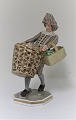 Bing & 
Grøndahl. 
Porcelænsfigur 
8045. Mand med 
Frugt kurv. 
Design :Tegner. 
Højde 18 cm. (1 
...