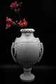 Dekorativ 
fransk 1800 
tals vase / 
urne i hvid 
porcelæn med 
hanke og 
blomster 
dekorationer. 
...