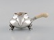 Georg Jensen 
Magnolia 
flødekande i 
hammerslået 
sterlingsølv 
med håndtag i 
elfenben. Model 
2C. ...