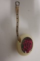 Measuring tool 
in a round 
holder, the 
holder is with 
a rose 
decorated
The measuring 
tape is ...