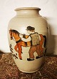 Vase i keramik fra Kähler-fabrikken. Dekoreret med ung mand og arbejdshest. Vasen fremstår i god ...