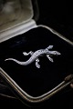 Gammel broche i 
sølv i form af 
salamander med 
masser af små 
skinnende 
magasiter. 
Måler: L:5cm.