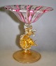 Venetian glass 
tazza, on a 
dolphin foot, 
20th century 
Italy. Height.: 
15.6 cm. Dia. 
bowl: 14 cm. 
...