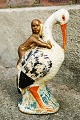 Sparebøsse i 
form af 
koldbemalet 
figur af stork 
med baby på 
ryggen. 
Fremstillet i 
slutningen af 
...