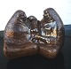 Brown glazed 
figure group 
with two seated 
women and a 
child in the 
middle. Two 
small 
"scratches" ...