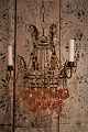 Gammel fransk lysekrone i forgyldt metal , dekoreret med glaskæder og glas kugler i klare og ...