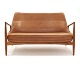 Ib Kofod-Larsen zwei Personen Sofa aus Teak bezogen mit patiniertem Leder. 
Design aus dem Jahre 1957. L: 138cm