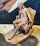 Figur i lertøj af mand i dragt fra roccotiden siddende i samtidig stol. Udført af C. F. Nielsen, ...