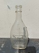Flaske med billed af ko i relief på den ene side og måle enhed på den anden side