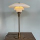 Poul 
Henningsen. 
Bordlampe 
model TrePH, 
jubilæumsmodel 
med stamme og 
fod af bruneret 
messing, ...