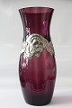 Flot antik vase 
i 
aubergine-
farvet glas, 
med 
tin-indfatning. 
Vasen er 27 
centimeter høj, 
og vil ...