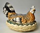 Porcelæns høne, 
19. årh. 
Tyskland. 
Koldbemalet 
porcelæn. 
Bestående af 
låg og bund. L. 
26 cm. H.: ...