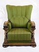 En højryggede lænestol fra renæssanceperioden polstret i grønt stof og dekoreret med ...