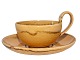 Kähler keramik gul tekop med høj hank og tilhørende underkop.Koppen måler 9,9 cm. i diameter ...