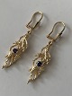 Beautiful gold 
earrings with 
purple stones 
hanging in the 
earring. The 
earrings are 
shaped like ...