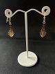 These gold 
earrings have a 
beautiful 
herring bone 
pattern and 
dynamic curved 
shape. The 
earrings ...