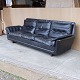 Fire personers 
sofa beklædt 
med sort læder 
monteret på ben 
af mørkt træ
Producent ...