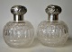 A pair of 
faceted crystal 
flasks with 
lids in 
sterling ...